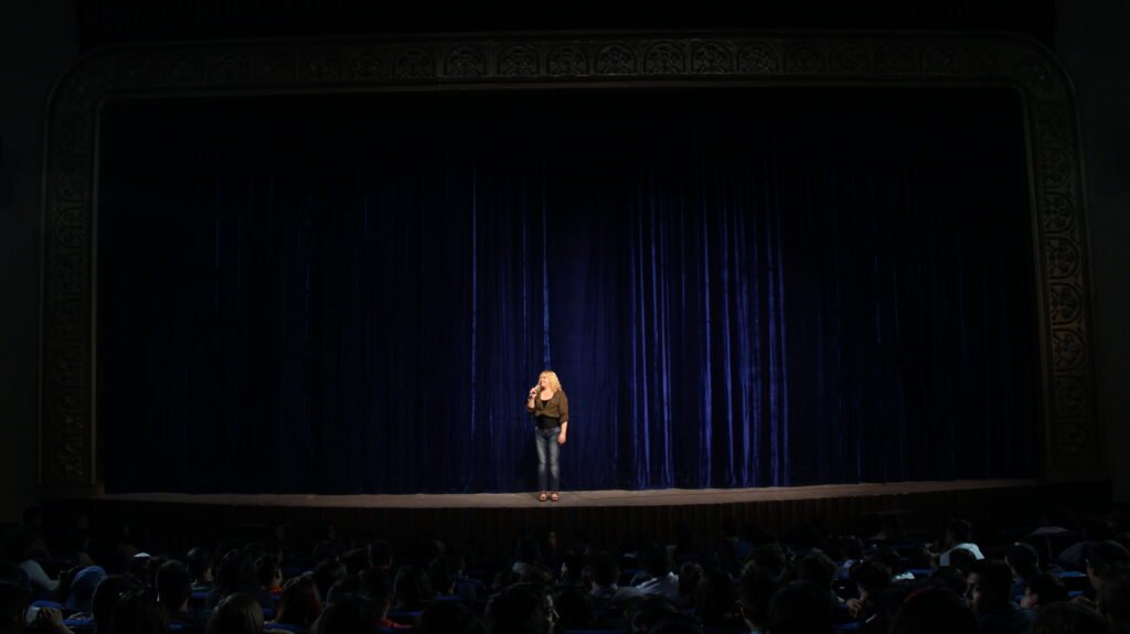 Marta Bernarda hablando al público desde el escenario antes de una función