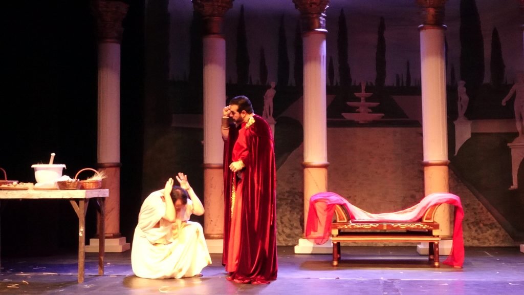Ovidio de pie junto a Policleto agachado en una escena de La Voz Poderosa